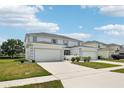 Front exterior of townhome with a well-maintained lawn, two-car garage and screened entry at 1986 Yellowfin Dr, Port Orange, FL 32128