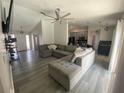 Spacious living room featuring a ceiling fan, open layout, and stylish gray laminate flooring at 2236 Dancy Trail Trl, Clermont, FL 34714