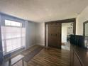 Cozy living room showcasing wood laminate floors, barn door, and a bright window with blinds at 2236 Dancy Trail Trl, Clermont, FL 34714