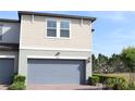 Exterior view showing the home's address above a spacious, two car, attached garage and manicured landscaping at 2415 Sweet Viburnum Way, Ocoee, FL 34761