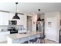 Modern kitchen with granite countertops, stainless steel appliances, island with seating, and pendant lighting at 2415 Sweet Viburnum Way, Ocoee, FL 34761
