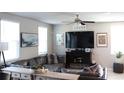 Inviting living room featuring a comfortable leather sectional, a ceiling fan, and bright natural light at 2415 Sweet Viburnum Way, Ocoee, FL 34761