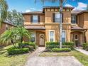 Charming townhome exterior featuring a brick walkway, verdant landscaping, and a welcoming entrance at 2744 Calabria Ave, Davenport, FL 33897