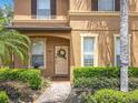 Home featuring manicured shrubbery leading to an inviting entryway with wreath adorned door at 2744 Calabria Ave, Davenport, FL 33897