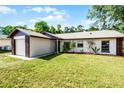Landscaped single-story house with a brick trimmed garage and expansive front lawn at 288 Howard Blvd, Longwood, FL 32750