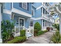 Blue townhome showcasing architectural details, inviting porch, and lush landscaping at 316 Solaris Wharf St, Winter Springs, FL 32708