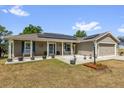 Inviting single-story home featuring a covered porch with rocking chairs and neat landscaping at 326 Woodland Trl, Lady Lake, FL 32159