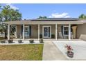 Cozy front porch with rocking chairs, decorative shutters, and potted plants at 326 Woodland Trl, Lady Lake, FL 32159