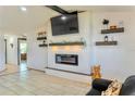 Bright living room featuring an electric fireplace, TV, and stylish decorative shelving at 3328 Fox Ridge, Winter Haven, FL 33884