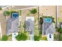 An aerial view showcases the property's layout, neighboring homes, and screened-in pools on a sunny day at 337 Giovani Blvd, Clermont, FL 34715