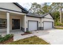 Close-up of the house's entrance and garage, showcasing the fresh landscaping at 3777 Sw 130Th Loop, Ocala, FL 34473