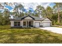 Lovely exterior shot of a single-story home with a well-maintained lawn and two-car garage at 3777 Sw 130Th Loop, Ocala, FL 34473