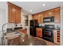 Modern kitchen features wood cabinets, granite countertops, black appliances and a laundry nook at 390 Lake Placid Ct # 304, Altamonte Springs, FL 32701