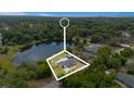 An aerial view showcasing the property's location near a pond, surrounded by abundant trees at 51 Spruce Ln, Debary, FL 32713