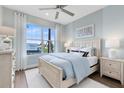 Bright bedroom featuring a plush bed, stylish decor, ceiling fan, and large window with pleasant outdoor views at 5262 Foothills Preserve Loop, Mount Dora, FL 32757