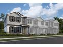Charming townhome exteriors featuring neutral paint, decorative shutters, and covered front entries, all surrounded by lush landscaping at 652 Pothos St, Apopka, FL 32703