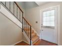 View of the condo entryway featuring carpeted stairs, wooden handrail, and white entry door with window at 7336 Daniel Webster Dr # 9, Winter Park, FL 32792