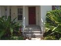 Charming entryway with a red door, decorative wreath, and fresh landscaping at 7415 Devereaux St, Reunion, FL 34747