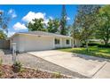 A charming one-story home features an attached two-car garage and a long driveway leading to the street at 821 Sutter Loop, Longwood, FL 32750