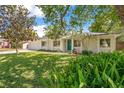 Beautiful single-story home featuring an expansive green lawn, mature trees, and a pop of color from the turquoise front door at 821 Sutter Loop, Longwood, FL 32750