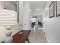 Inviting hallway with tile flooring, neutral paint, and access to various rooms at 9007 Pelican Cove Trce, Kissimmee, FL 34747