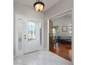 Bright foyer with tile flooring, decorative glass front door, and view into the living room at 115 Oak Grove Cir, Lake Mary, FL 32746