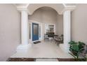 Inviting front porch with white columns, seating area, and a blue front door at 115 Oak Grove Cir, Lake Mary, FL 32746