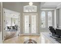 Bright foyer featuring a decorative compass floor inlay and views of the dining room and office at 11508 Delwick Dr, Windermere, FL 34786