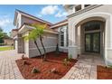Elegant entryway with double doors, arched windows, and lush landscaping at 11508 Delwick Dr, Windermere, FL 34786
