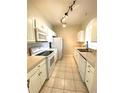 Well-lit kitchen with white appliances, ample cabinet space, and neutral tile flooring at 1224 S Hiawassee Rd # 638, Orlando, FL 32835