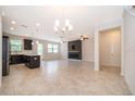 Open-concept living room featuring tile floors, modern fireplace, and black kitchen cabinets at 1227 Sandwedge St, Davenport, FL 33896