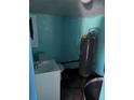 Small blue bathroom showing a toilet, sink, water heater, and some staining on the floor at 1231 Leon Ln, Daytona Beach, FL 32117