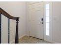 Bright entryway featuring a decorative glass front door and an elegant staircase with a dark wood handrail at 141 Mitchell Creek Way, Oviedo, FL 32765