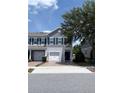 Charming two-story townhome featuring a one-car garage, blue shutters, and a welcoming brick driveway at 141 Mitchell Creek Way, Oviedo, FL 32765