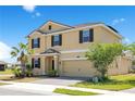Two-story home with a two-car garage, a lush tree, and neutral-colored exterior with brown shutters at 1504 Oak Marsh Loop, Davenport, FL 33837