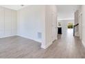Hallway with gray wood-look tile leading to the kitchen and backyard at 1504 Oak Marsh Loop, Davenport, FL 33837