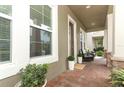 Inviting front porch with brick flooring, columns, and a cozy seating area at 15849 Sweet Lemon Way, Winter Garden, FL 34787