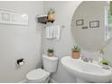 Well-lit powder room featuring a modern vanity, decorative mirror, and stylish wall decor at 16163 Pebble Bluff Loop, Winter Garden, FL 34787