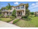 Charming two-story townhome featuring manicured landscaping and a welcoming entrance with a brick walkway and cozy seating at 16163 Pebble Bluff Loop, Winter Garden, FL 34787