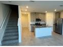 Modern kitchen with stainless steel appliances, granite countertops, and a spacious island at 16468 Happy Eagle Dr, Clermont, FL 34714