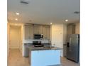 Modern kitchen with stainless steel appliances, granite countertops, and a spacious island at 16468 Happy Eagle Dr, Clermont, FL 34714