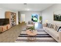 Open living room featuring neutral decor, modern furnishings, and sliding glass doors to the backyard at 16518 Brook Springs Aly, Winter Garden, FL 34787