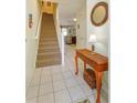 Bright foyer with neutral tile floors, staircase, and decorative table with mirror at 2348 Silver Palm, Kissimmee, FL 34747