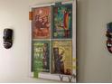 Wall decor featuring four 'Enchanted Tiki Room' posters in a vintage window frame and a tiki mask at 2348 Silver Palm, Kissimmee, FL 34747
