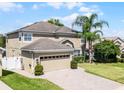 Lovely home featuring a brick driveway, two-car garage, and manicured lawn with landscaping at 2411 Sabastian St, Mount Dora, FL 32757