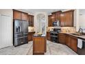 The kitchen features wooden cabinetry, stainless steel appliances, and a center island at 2411 Sabastian St, Mount Dora, FL 32757