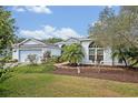 Lovely single-story home with a manicured lawn, garden beds, and a convenient two-car garage at 25057 Riverwalk Dr, Leesburg, FL 34748