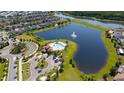 Aerial shot showcases a community pool, lakeside views, and beautifully maintained grounds at 2790 Monticello Way, Kissimmee, FL 34741