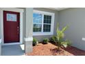 Inviting entrance with a red door and charming front garden at 306 Marion Oaks Crse, Ocala, FL 34473
