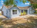 Side view of a light-blue single-story house showcasing the well-kept lawn and charming architecture at 329 Drake Elm Dr, Kissimmee, FL 34743